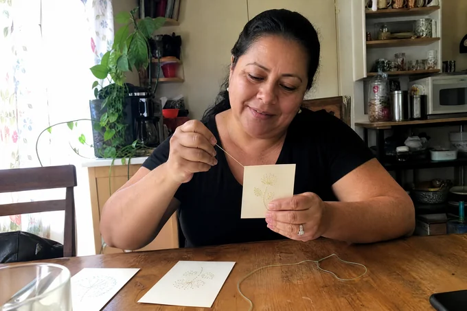 Thérèse D. brodant sa carte sur papier